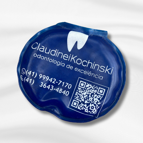 Bolsa térmica quente e fria exclusiva do consultório odontológico Claudinei Kochinski toda em azul, com a logo e os telefones de contato.